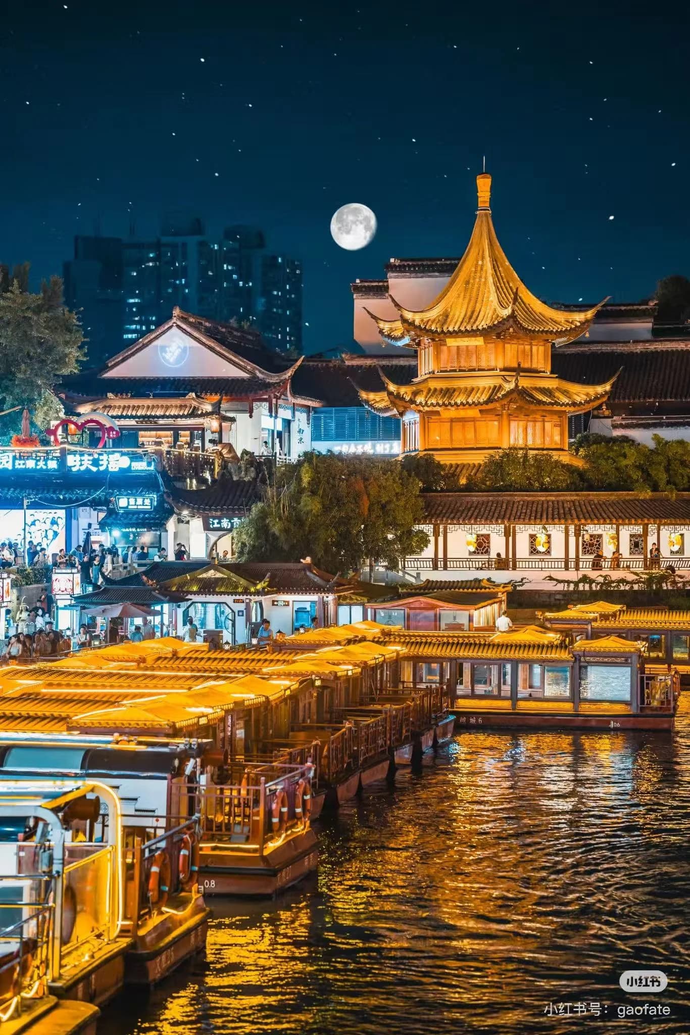 Confucius Temple area lit up at night with reflections on the Qinhuai River