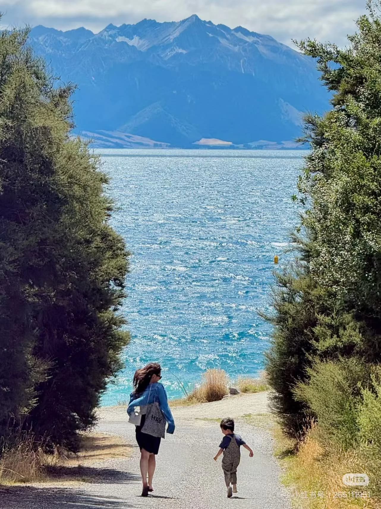 Child watching a giant panda eating bamboo at Chengdu Research Base, surrounded by green bamboo groves
